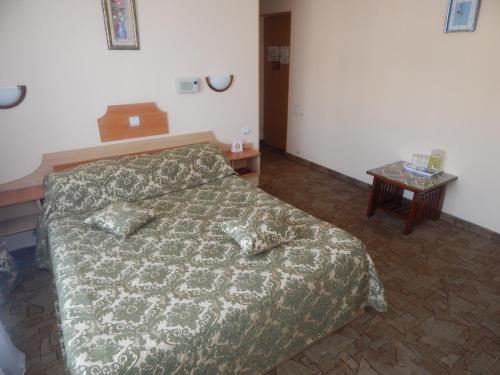 a bedroom with a bed and a table at Гостиница ИЛЕК in Aktobe