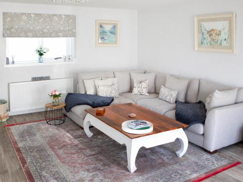 ein Wohnzimmer mit einer Couch und einem Couchtisch in der Unterkunft Rose Cottage in Dingwall