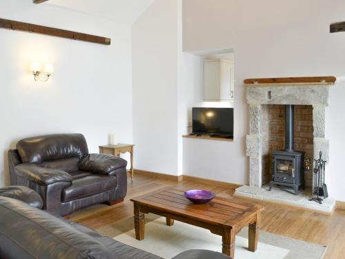 a living room with a couch and a fireplace at The Coach House in Whittingham