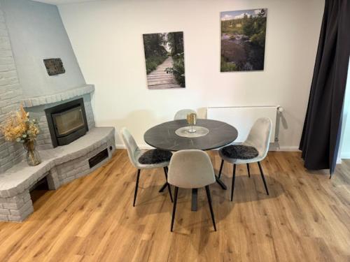 a dining room with a table and chairs and a fireplace at Fabians Ferienhaus - 4 besondere Ferienwohnungen in Simmerath