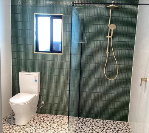 a bathroom with a toilet and a glass shower at Malanda Falls Retreat in Malanda