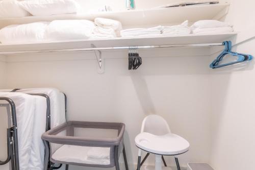 Cette chambre comprend des lits superposés et 2 chaises. dans l'établissement Emerald Escape, Free Parking, 2 Bath, Sleeps 8 Near American Dream and The Airport, King Bed and 2 Queen Beds, Washer and Dryer, à Orange