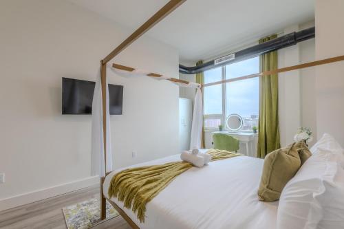une chambre avec un lit blanc et une grande fenêtre dans l'établissement Emerald Escape, Free Parking, 2 Bath, Sleeps 8 Near American Dream and The Airport, King Bed and 2 Queen Beds, Washer and Dryer, à Orange