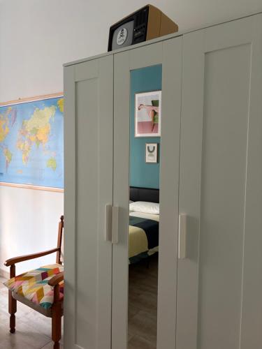 a room with a bed and a cabinet with a clock on top at Jaky Maison Torino, Cozy & Modern Stay in Turin