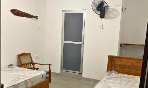 a room with two beds and a window and a fan at N28 Negombo in Negombo