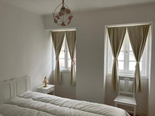 een slaapkamer met een bed en twee ramen bij Melro-d' água in Manteigas