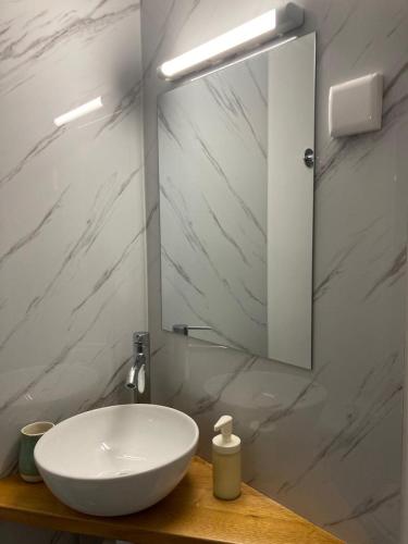 a bathroom with a white sink and a mirror at Melro-d' água in Manteigas