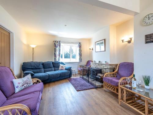 een woonkamer met een blauwe bank en stoelen bij Old Alton Hall Farmhouse in Tattingstone