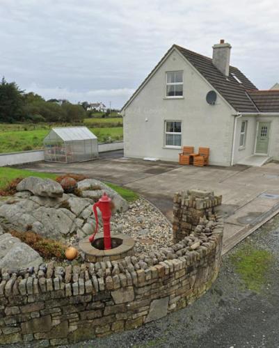 a fire hydrant in a stone wall in front of a house at Sonnys Rest in Ardara