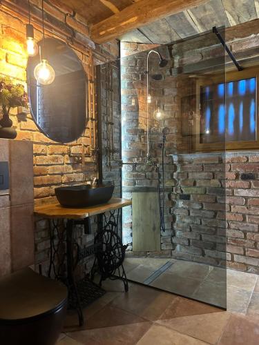 a bathroom with a sink and a stone wall at Podroom LauMarYvo in Dugo Selo