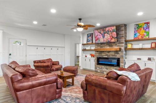 a living room with leather furniture and a fireplace at The Tree House on Lake Brownwood in Brownwood