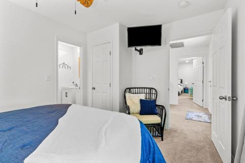 a bedroom with a bed and a chair and a tv at The Tree House on Lake Brownwood in Brownwood