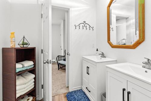 a white bathroom with a sink and a mirror at The Tree House on Lake Brownwood in Brownwood