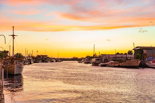 a group of boats docked in a river at sunset at Luxury Family Beach Escape with Heated Pool and Putting Green in Tarpon Springs