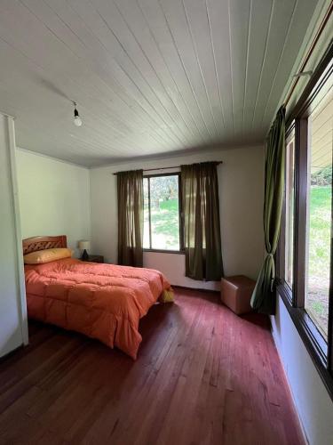 Un dormitorio con una cama y una ventana grande. en Casa en Panguipulli, en El Cerrillo