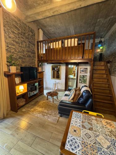 a living room with a couch and a staircase at Victoria Tiny Stone House in Ponta do Pargo