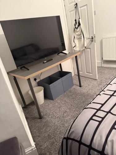 a desk with a television on it in a room at City Apartment in Litherland