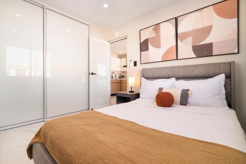une chambre avec un grand lit avec un oreiller orange dessus dans l'établissement SunJoy Gateway Lux 2 bedroom House by PH, à Carolina