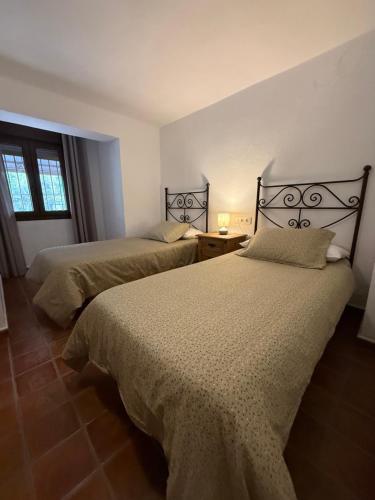 ein Schlafzimmer mit zwei Betten und einem Fenster in der Unterkunft Casa Rural Orilla del Hueznar in Cazalla de la Sierra