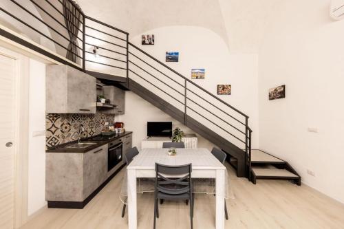 una cucina e una sala da pranzo con tavolo e scala di Volcano Home a Catania