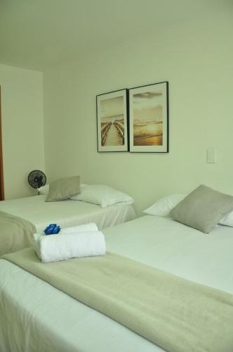 three beds in a room with three pictures on the wall at live Medellín desde un Apartamento Céntrico y Cómodo in Medellín