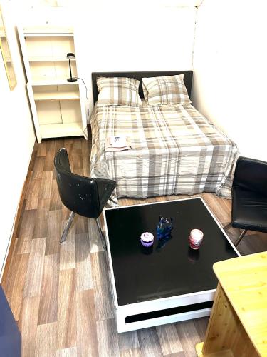 a room with a bed and a laptop on the floor at Christalsuite in Frameries