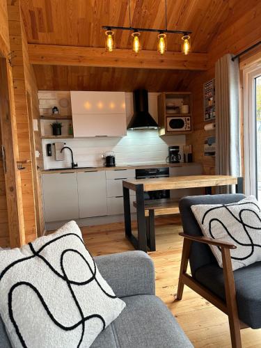 a kitchen and living room with a couch and a table at The Cabin log fire cosy home in Folkestone