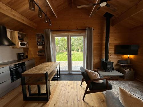 a kitchen with a wooden table and a large window at The Cabin 6 minutes from the Eurotunnel in Folkestone