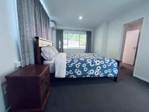 a bedroom with a bed and a window at Holiday Home In Red Hill Papakura Auckland in Buckland