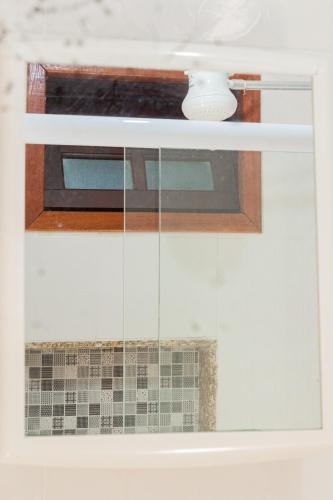 a window in a kitchen with a microwave at Pousada Panceiro in Cabo Frio