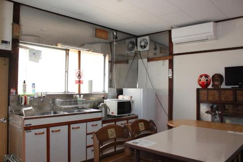 une cuisine avec un évier et une table avec des chaises dans l'établissement Oyado Sakura - Vacation STAY 88440v, à Matsumoto