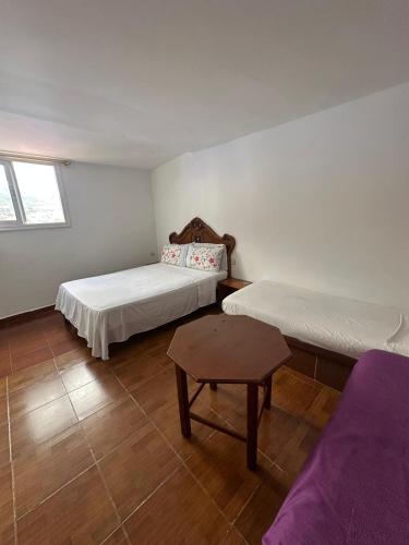 a room with two beds and a table in it at Nouara Appart'Hotel in Chefchaouen