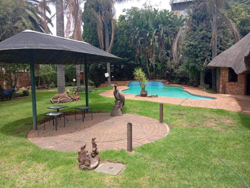 a park with a fountain with statues in the grass at Aero Garden Ensuite in Johannesburg