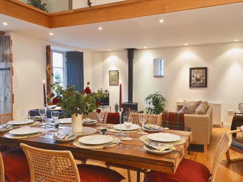 a dining room with a large wooden table and chairs at Shaplands Barn in Cold Ashton