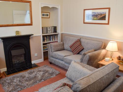 a living room with two couches and a fireplace at Pear Tree Cottage in Bowness-on-Windermere