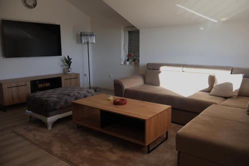 a living room with a couch and a coffee table at Apartmani Ana in Čapljina