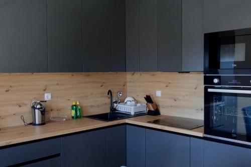 a kitchen with a counter with a sink and a microwave at Apartmani Ana in Čapljina