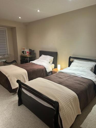 a bedroom with two beds and a table with a chair at Toronto downtown Woodbine beaches private cozy room in Toronto