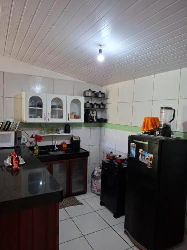 a kitchen with a black refrigerator in a room at Casa no Sítio - Guaramiranga in Guaramiranga