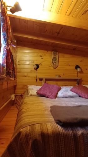 a bedroom with a bed with two pillows on it at Hospedaje Las Gardenias in Lago Puelo