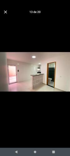 a picture of a room with a kitchen and a counter at Quarto de descanso na baixada in Mesquita