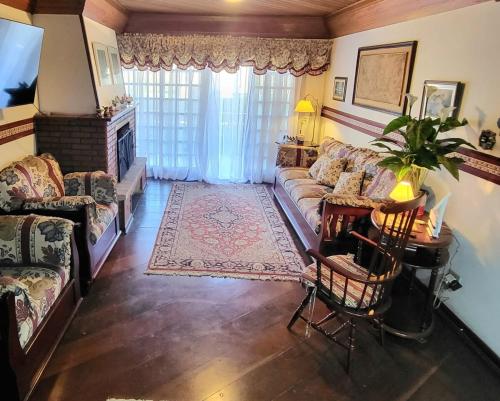 APART Deluxe Campos do Jordāo com lareira في كامبوس دو جورداو: غرفة معيشة بها أريكة وطاولة