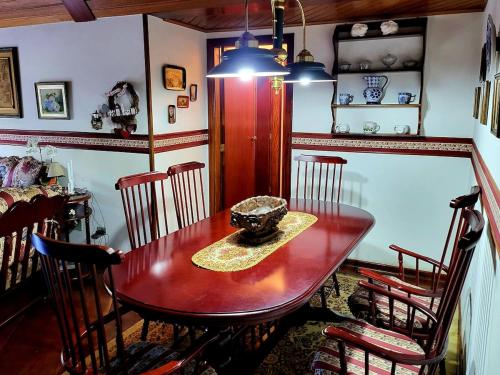 APART Deluxe Campos do Jordāo com lareira في كامبوس دو جورداو: غرفة طعام مع طاولة وكراسي خشبية