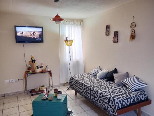 a bedroom with a bed and a tv on the wall at A pasos de la terminal in Viedma