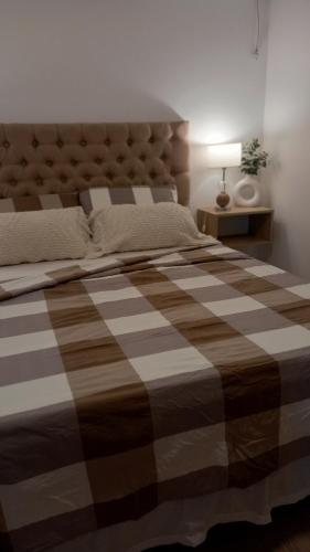 a bedroom with a large bed with a brown and white blanket at Departamento de lujo El Monte in San Nicolás de los Arroyos