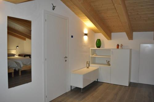 a white room with a bed and a white door at Giardino di Lei, appartamento giallo in Montegrotto Terme