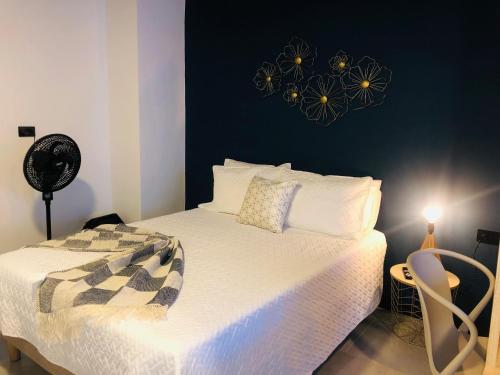 a bedroom with a white bed with a black wall at HAB 108- Hermosa, cómoda y moderna in Medellín