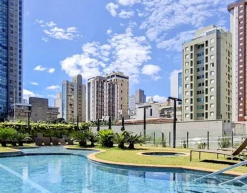 a large swimming pool in a city with tall buildings at FLAT de luxo mobiliado na Savassi in Belo Horizonte