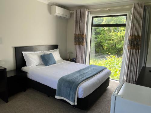 TamahereTamahere Lifestyle的一间卧室，里面有一张床和一扇大窗户。