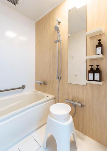 a bathroom with a toilet and a tub and a sink at 海街ゲストハウス in Takamatsu